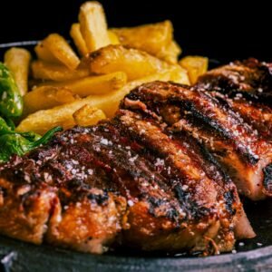 Succulent grilled steak served with crispy fries and roasted green peppers.