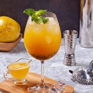 A chilled passion fruit cocktail garnished with mint, perfect for summer enjoyment.